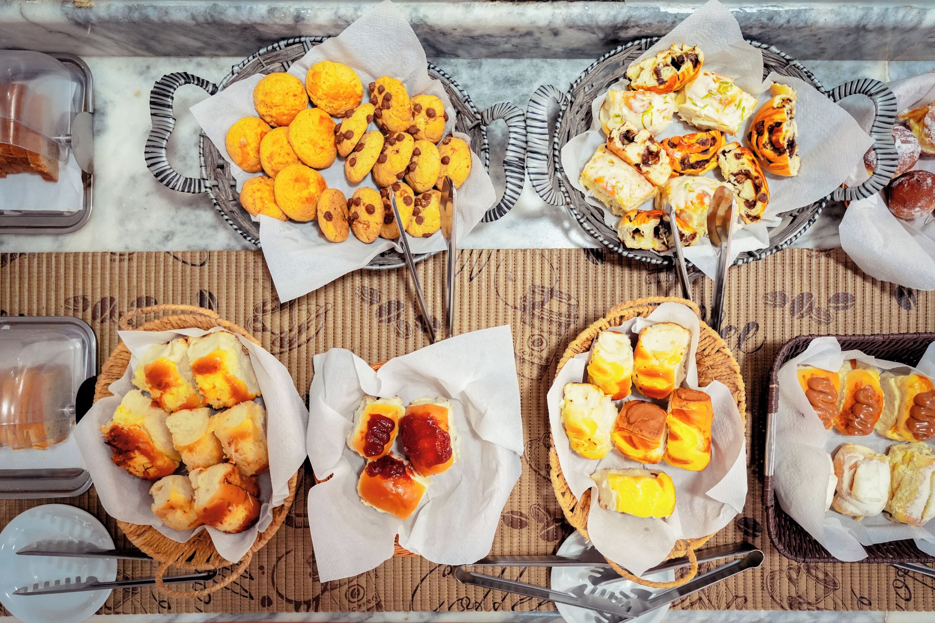 Diversos productos de panadería horneados sobre una mesa con moldes de papel.