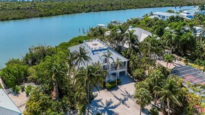A coastal property with a large house, a dock, and a view of the ocean. - Stunning bayside retreat with golf cart! (Captiva)