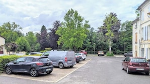 A parking lot with several cars and a building in the background. - Studio 1: Charm and convenience  (Gond-Pontouvre)