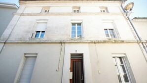 A two-story building with a central entrance door, windows on the upper floor, and a satellite dish on the roof. - Studio 1: Charm and convenience  (Gond-Pontouvre)