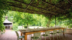A covered outdoor dining area with a long wooden table and six chairs. - Mulino Di Amarrante Countryhouse  (Montaione)