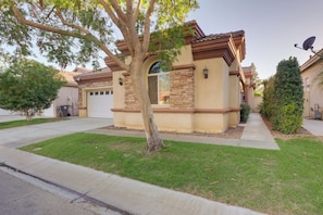 A residential house with a garage, a tree in front, and a well-maintained lawn. - 2 Mi to Coachella Grounds: Home w/ Fire Pit! (Indio)