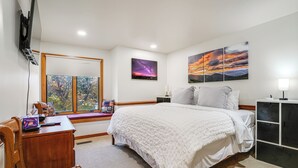 A bedroom with a bed, a desk, a chair, a TV, and artwork on the walls. - 1 Mi to Wintergreen Resort: Mtn-view Condo! (Nellysford)