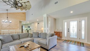 A spacious living area with a sectional sofa, a wooden coffee table, and a ceiling fan. - Walk to Gulf: Tranquil Home w/ Yard in Pcb! (Panama City Beach)
