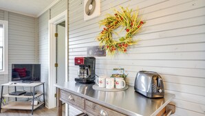 A kitchen with a stainless steel countertop, a coffee maker, a toaster, and a decorative wreath. - Lake Views & On-site Hiking: Cape Fair Cottage (Cape Fair)