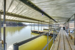 A covered dock area with a metal roof and wooden benches. - Lake & Trail Access: Cape Fair Cottage w/ Deck (Cape Fair)
