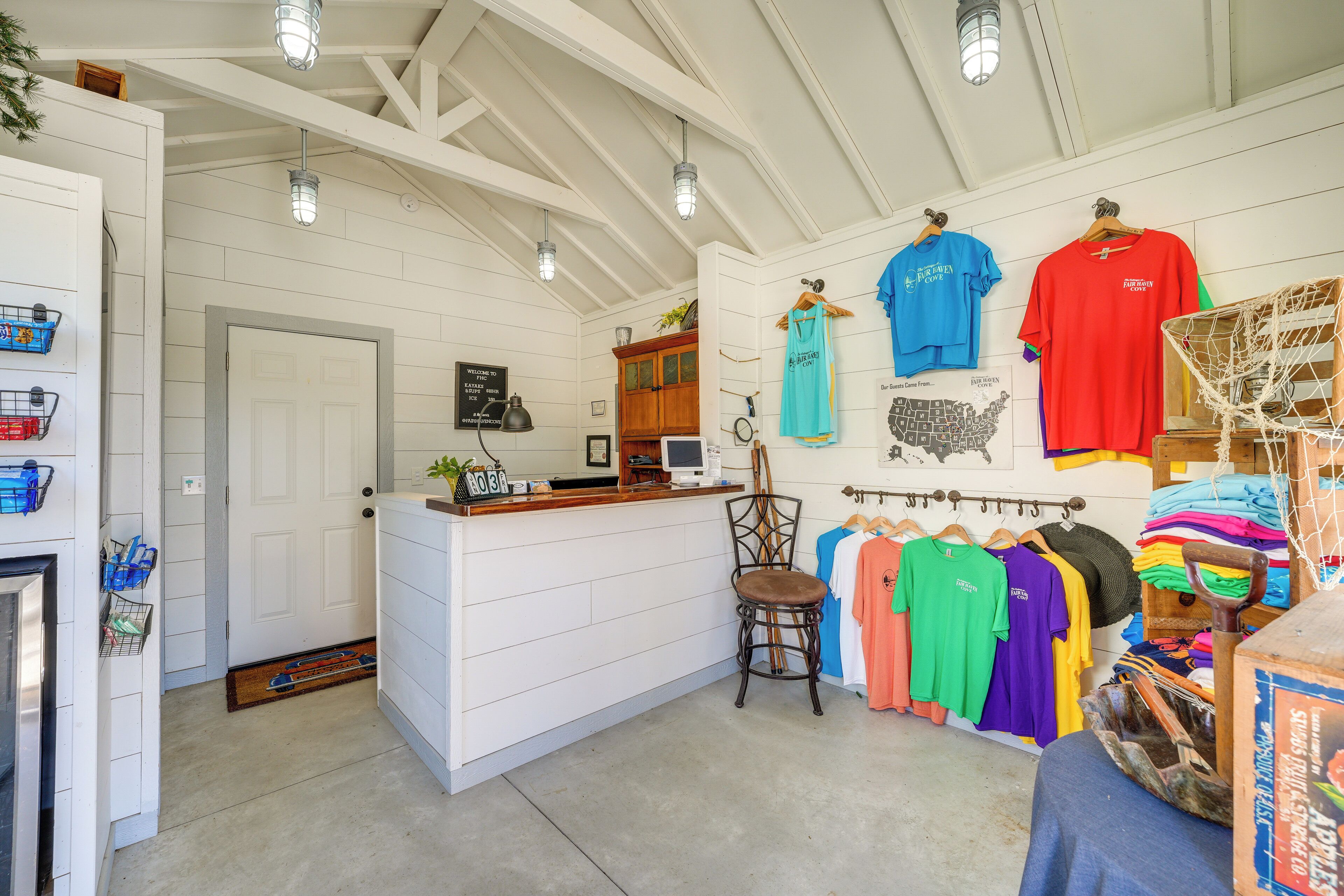 A room with a white wooden interior, a reception desk, and a wall displaying various sports jerseys.