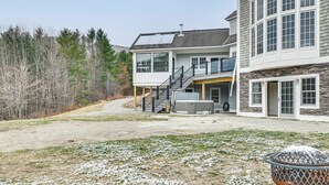 A two-story house with a covered porch, a garage, and a large outdoor fire pit.