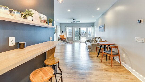 A modern kitchen with wooden countertops, a bar area, and a seating area with a sofa and chairs.