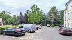 A parking lot with several cars and a building in the background. - Studio 5: Your urban oasis.  (Gond-Pontouvre)