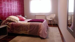 A bedroom with a bed, a chair, a radiator, and a window. - Modern apartment on the Fisterra Road (Negreira)