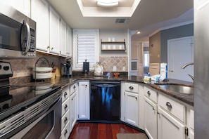 A modern kitchen with stainless steel appliances, white cabinetry, and a built-in dishwasher. - 7477 Anchorage: 2 Bed, 2 Bath, Steps to Marina, Free Bikes, Pool (Hilton Head Island)