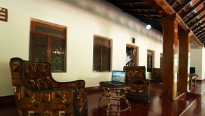A spacious lobby with traditional wooden furniture and a laptop on a small table.