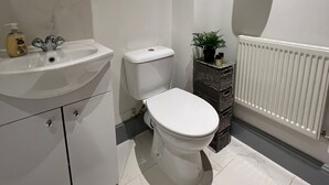 A bathroom with a white sink, toilet, and radiator. - The Penthouse Loft with Skyline views (Northampton)