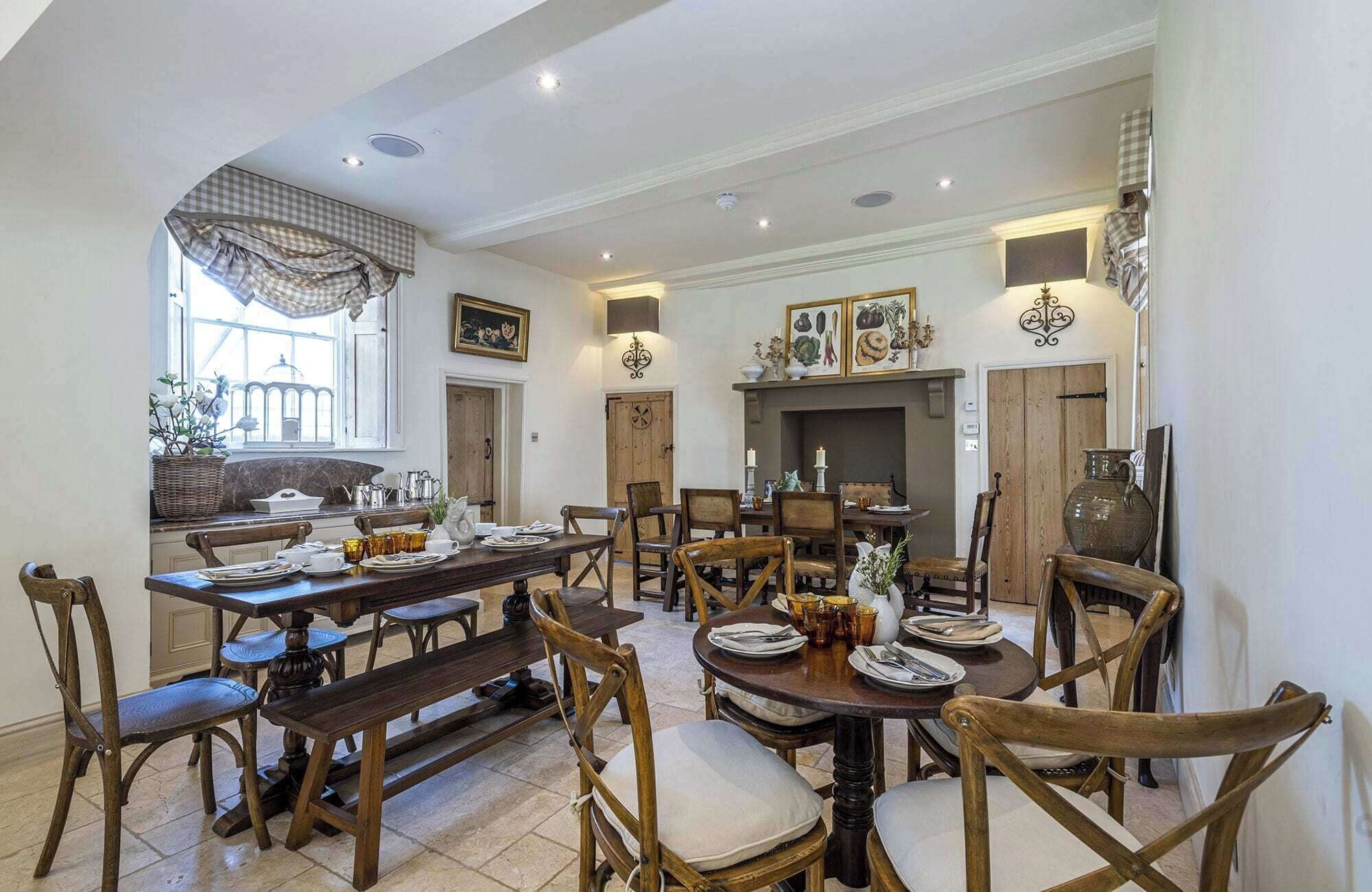 Une salle à manger spacieuse avec une longue table en bois, de nombreuses chaises et une cheminée.