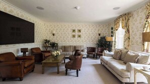A traditional living room with a sofa, armchairs, a coffee table, and a fireplace. - Ormesby Manor - 8 Beds - Sleeps 16 - Hot Tub (Great Yarmouth)