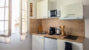 A compact kitchen with a microwave, coffee maker, and utensils on the counter. - Studio 3 - Cocon Douillet : Le Confort  (Gond-Pontouvre)