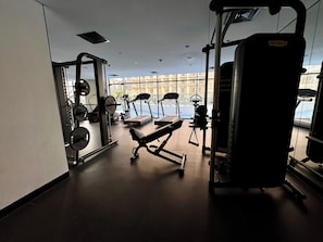 A gym with various exercise equipment, including treadmills, weight machines, and free weights. - Easygo-upgraded 1bdr Mageye MBR (Dubai)