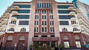 A multi-story hotel with a modern facade, large windows, and balconies. - Easygo- Spaciou STU With Pool Viewlp17 (Dubai)