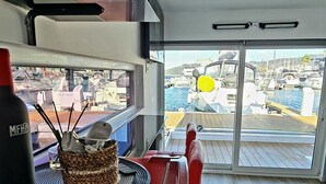 A kitchen area with a red appliance, a basket with utensils, and a view of a marina with boats. - Floating apartment in the nautical Vigo ferry dock Cies Islands and Cangas (Vigo)
