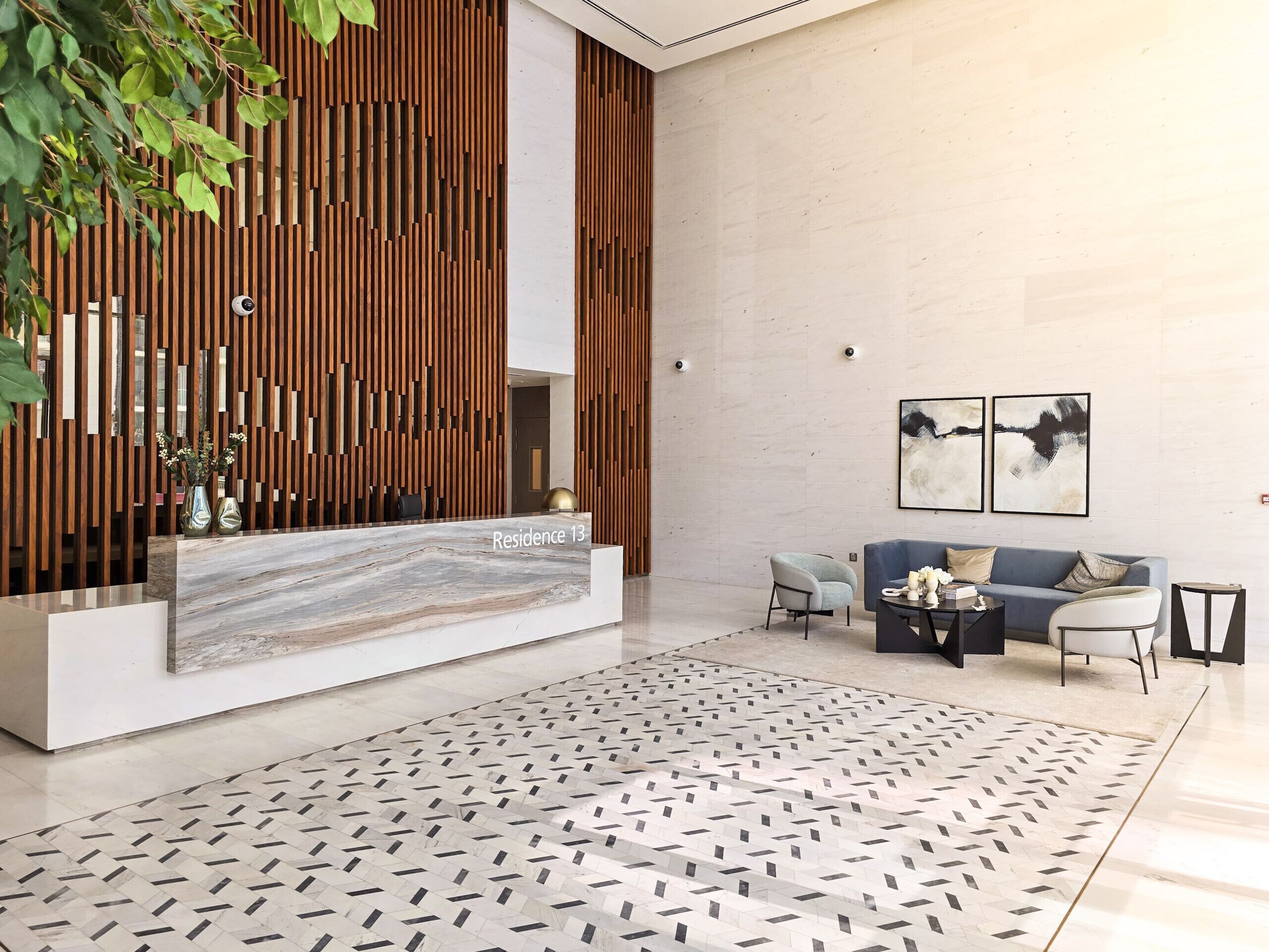 A modern reception desk with a marble top, a wooden slatted wall, and a patterned rug.