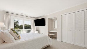 A bedroom with a bed, a TV, a desk, and a walk-in closet. - Hellenic Haven 6 Bedroom Home (Georgetown)