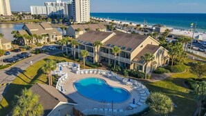 A resort with a swimming pool, beach access, and high-rise buildings in the background. - Grandview 2 Bedroom Condo (Miramar Beach)