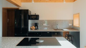 A modern kitchen with a built-in stove, microwave, and granite countertop.