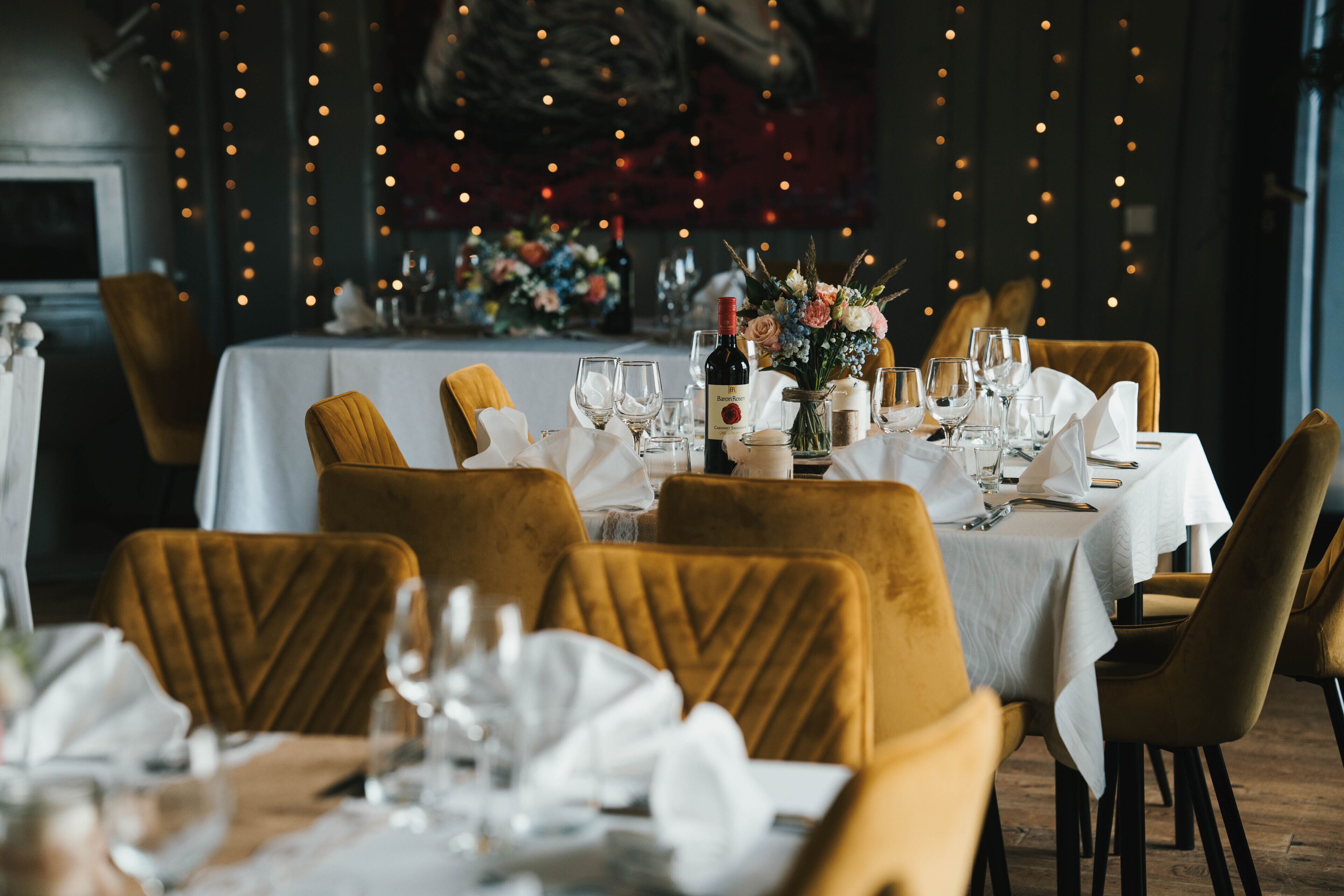 Un interior de restaurante con mesas dispuestas para comer, sillas y una decoración central.