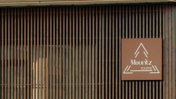 Une enseigne avec l’inscription « Mouritz rooms » sur un fond marron.