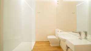 Une salle de bain moderne équipée de toilettes, d’un lavabo et d’un miroir.