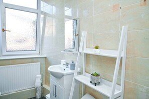 Een douche, handdoeken, zeep, toiletpapier