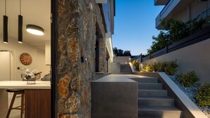 Una cocina moderna con una pared de piedra, una barra de madera y un reloj en la pared.