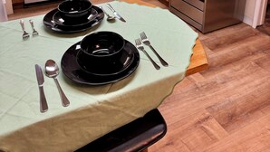 Uma cozinha com armários de madeira, lava-louças de aço inoxidável, fogão e micro-ondas.