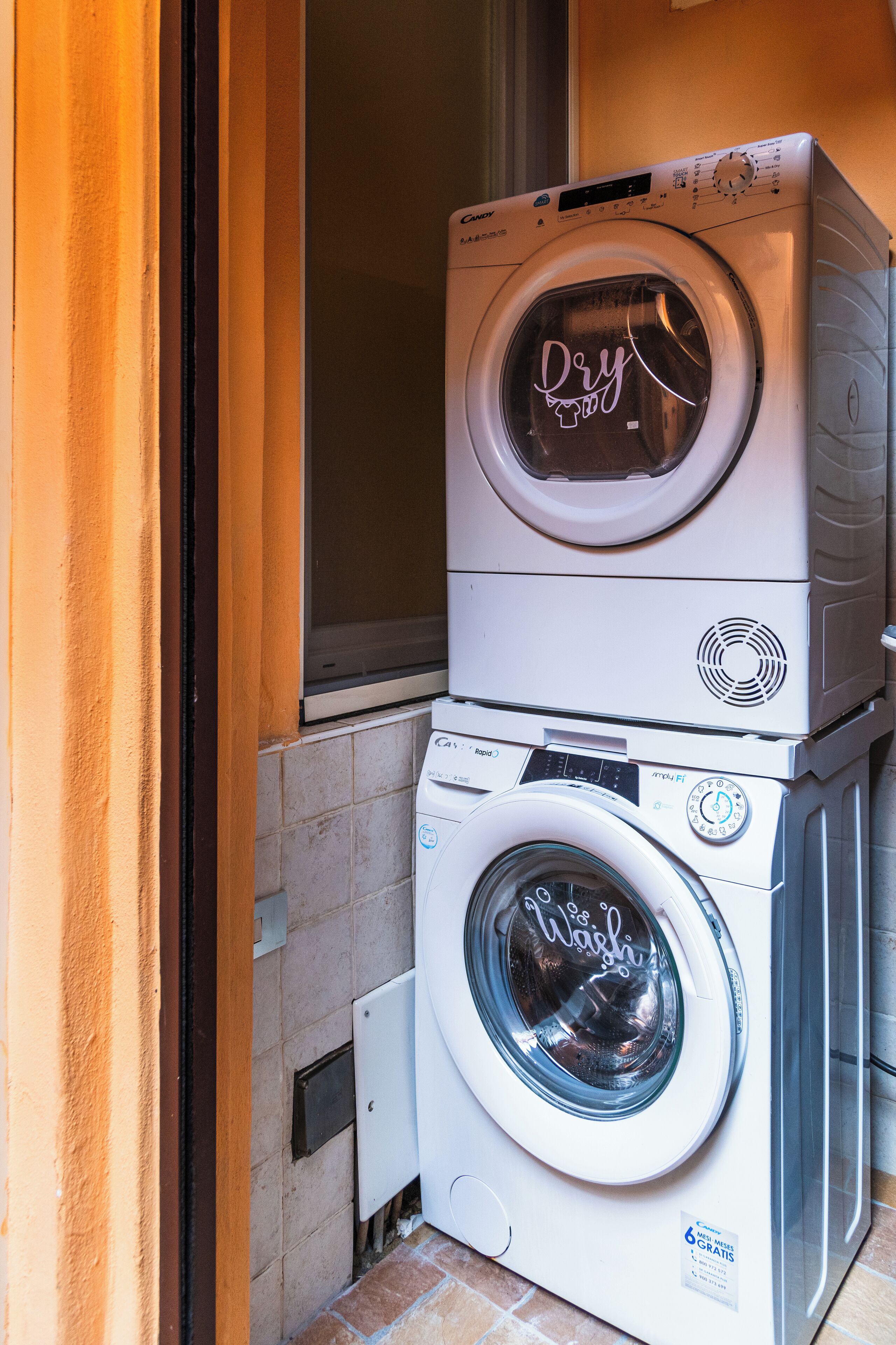 A stacked washer and dryer unit in a laundry room.
