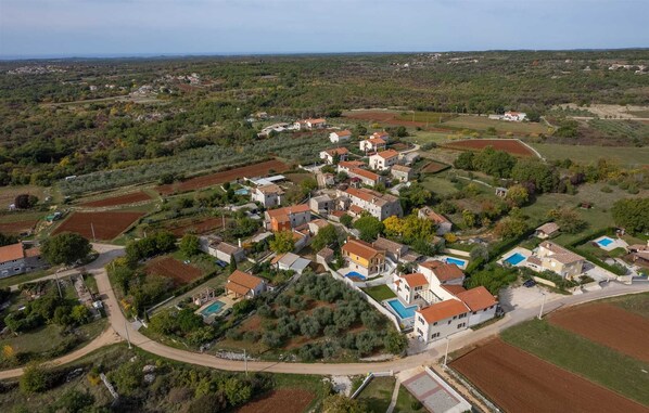 An aerial view of a residential area with houses, roads, and fields. - Villa Rova (Vošteni)