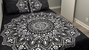 Um quarto com uma cama, uma porta e uma parede.