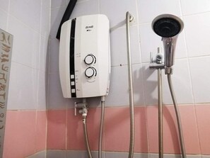 A wall-mounted water heater with two control knobs and a shower head attached to a flexible hose. - COZY SUN GARDEN at Grace Court Apartment (Kota Kinabalu)