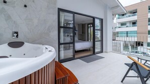 A modern bathroom with a freestanding bathtub, a wooden bench, and a glass-enclosed shower area. - UP Hotel Boutique (Bombinhas)