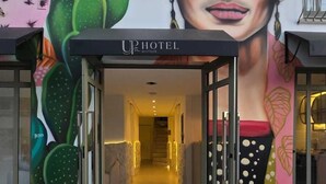 The entrance of UP HOTEL with a mural of a woman and cacti on the wall. - UP Hotel Boutique (Bombinhas)
