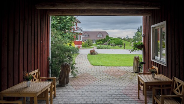 A wooden interior with a brick pathway leading outside. - Klaara-Manni Holiday Center (Randivälja)