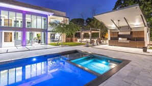 A modern house with a swimming pool, outdoor kitchen, and patio area. - Gated 9BR Estate for 20 w/ Private Pool, Jacuzzi, Theater & Guest House! Pet-Friendly! (Southwest Ranches)
