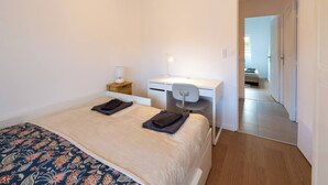 Une chambre à coucher avec un lit, un bureau et une chaise.