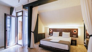 A hotel room with a large bed, a sliding glass door, and a modern headboard.