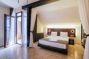 Een hotelkamer met een groot bed, een schuifdeur en een modern hoofdeinde.