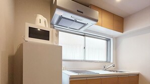 A compact kitchen with a refrigerator, stove, and sink. - Celine Kanayama 501 (Hiroshima)