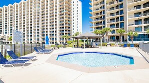 A hotel pool area with lounge chairs, a gazebo, and a sign detailing pool rules. - Beachfront 3BR! New to the Market! Just Renovated! (Orange Beach)