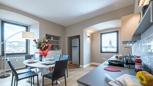 A modern kitchen with a dining area, a refrigerator, and a view of a cityscape. - QUINTO -TOP VIEW OF FLORENCE (Florence)