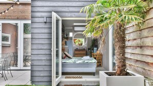 Une chambre à coucher de taille réduite, comprenant un lit, une petite table et une chaise.