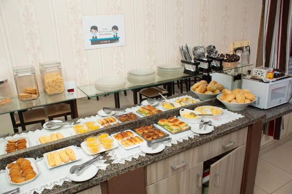 A buffet with various food items, including bread, pastries, and a microwave.